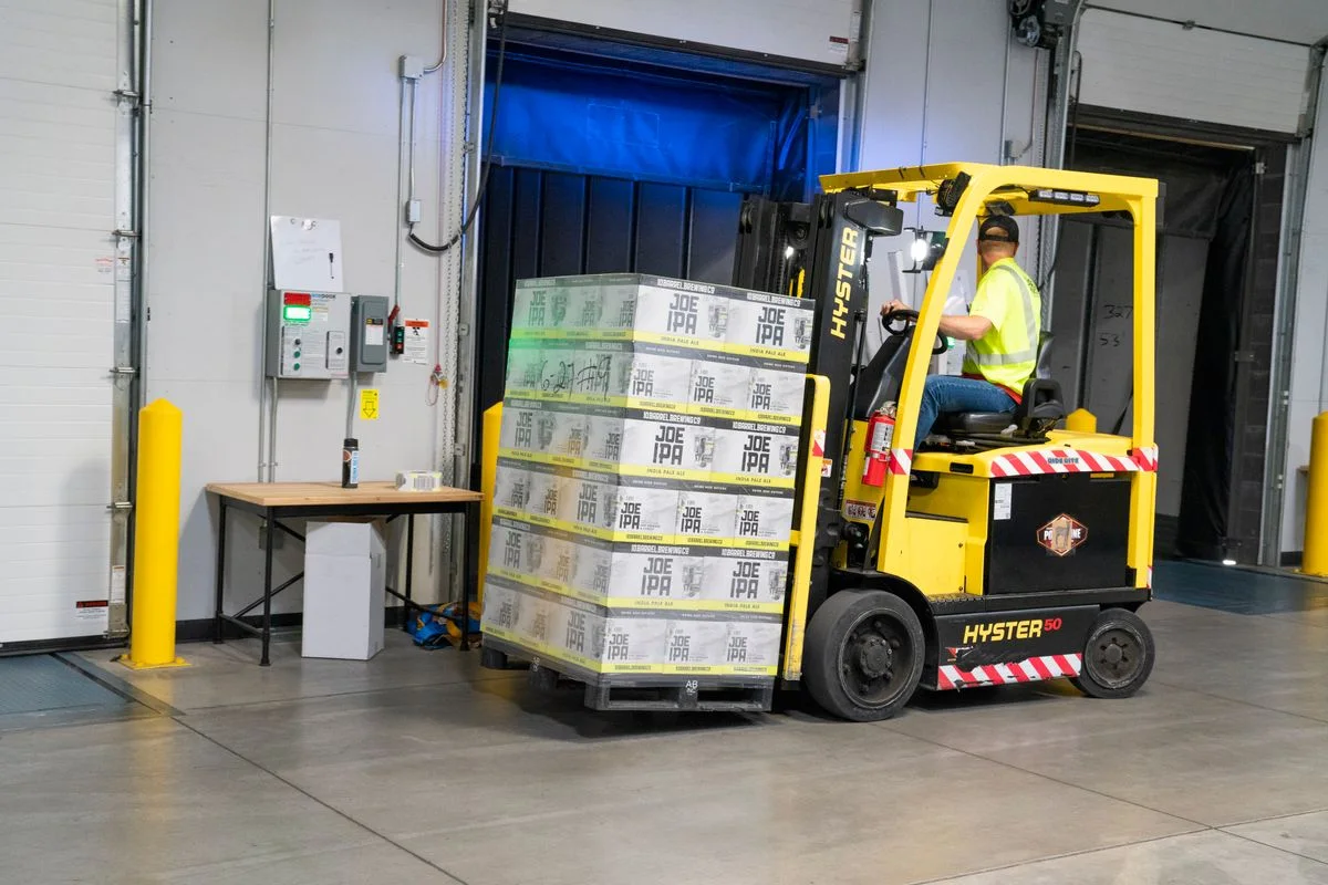 Warehouse forklift operator moving freight indoors